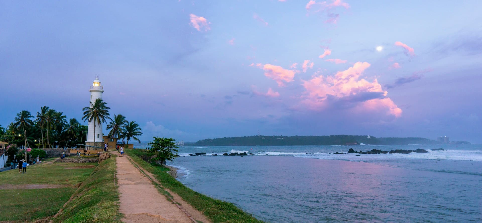 Galle lighthouse beside the ocean at sunset